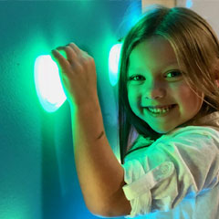 Young girl on climbing wall with illuminated GlowHolds