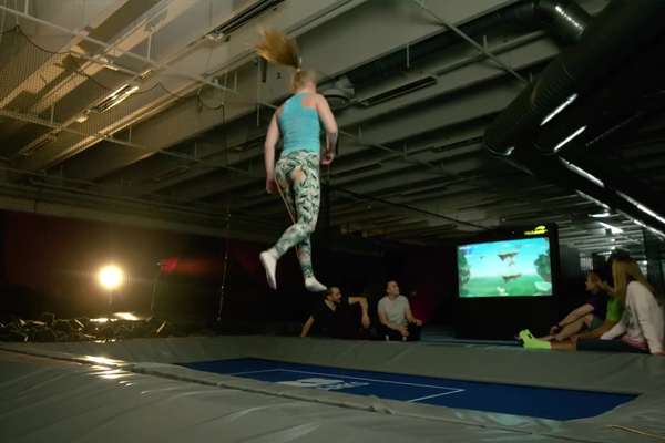 Young female plays ValoJump by jumping on trampoline