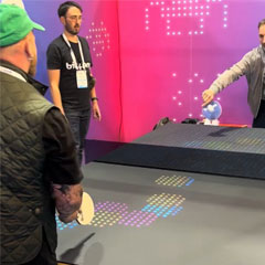 Guests play a game of Bit-Pong digital table tennis during a corporate expo event