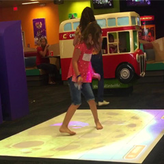 Girl plays on interactive MagixFloor Arcade platform