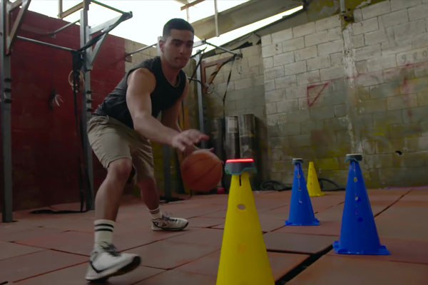 Man fitness training with basketball and BlazePod touch sensors
