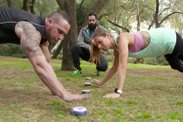 Man and woman training outdoors with fitness tech BlazePod wireless touch sensors