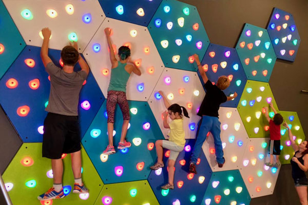 Kids play on GlowHolds interactive climbing wall