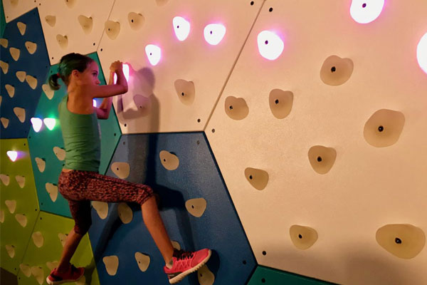 Young girl on climbing wall with GlowHolds