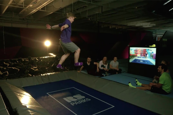 Young man bouncing on trampoline while playing ValoJump by Valo Motion